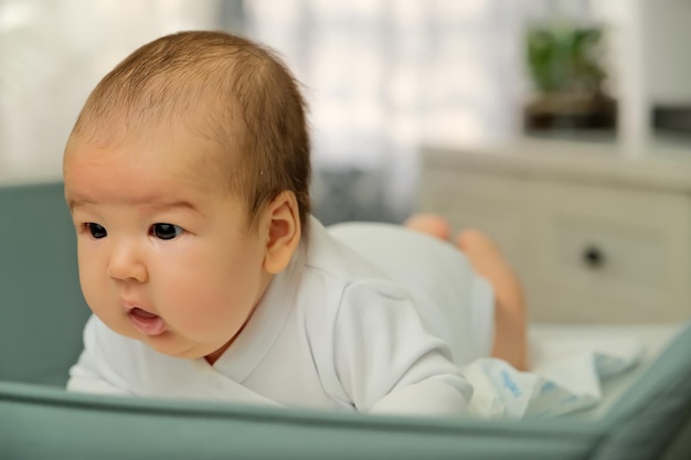 Pasgeboren baby ligt op de commode toont emoties pasgeboren baby leert zijn hoofd vast te houden