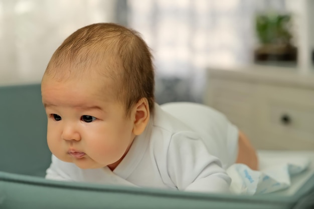 Pasgeboren baby ligt op de commode toont emoties pasgeboren baby leert zijn hoofd vast te houden