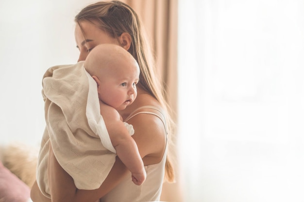 Pasgeboren baby met moeder op het bed