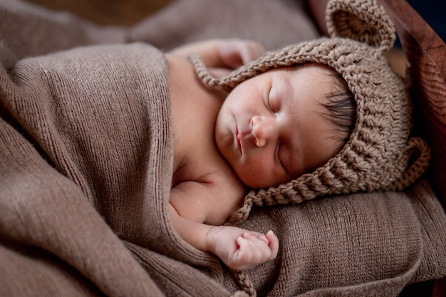 Pasgeboren baby, mooie baby ligt in een bruine vachtdeken