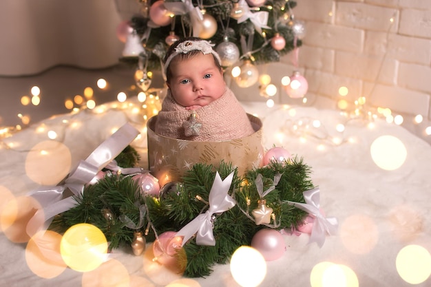 Pasgeboren baby op de achtergrond van kerstbomen slingers