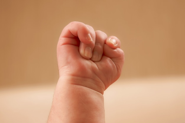 Pasgeboren baby's hand in een vuist gebald