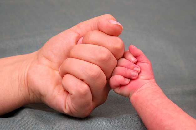 Pasgeboren baby's vuisthand en vuist van de ouders samen