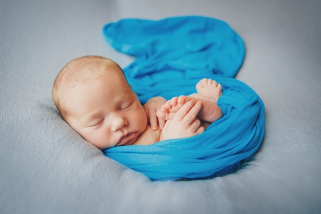 Pasgeboren baby slaapt gewikkeld in een deken