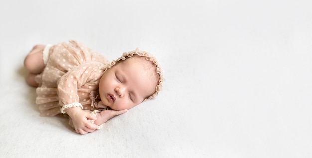 Pasgeboren baby slaapt heerlijk met zijn handpalmen tegen zijn wang gedrukt en zijn mond een beetje open