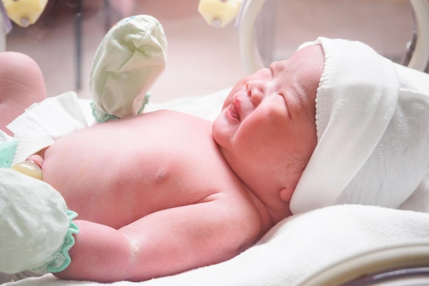 Pasgeboren baby slaapt in de couveuse in het ziekenhuis