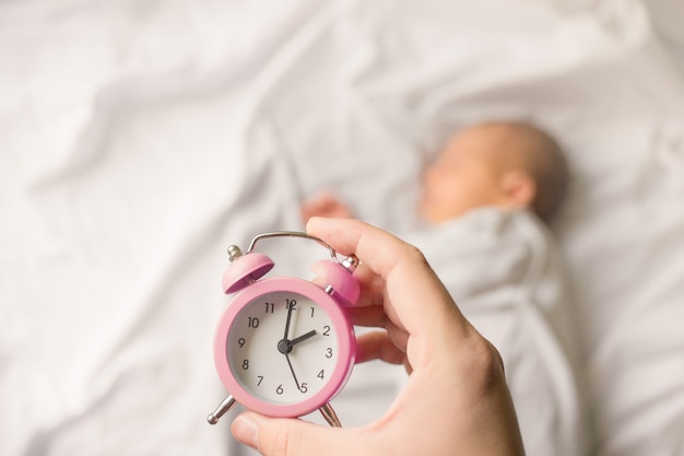 Pasgeboren baby slapen in een omslag op witte deken