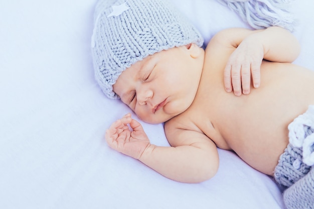pasgeboren baby slapen met grijze hoed en slipje
