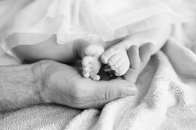 Pasgeboren baby voeten in moeder handen Moeder met benen van het kind in handen Close-up beeld