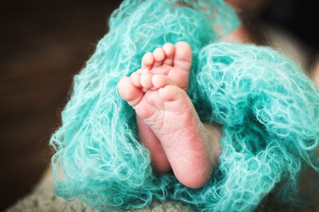 Pasgeboren baby voeten. kinderbenen gewikkeld in een blauwe deken