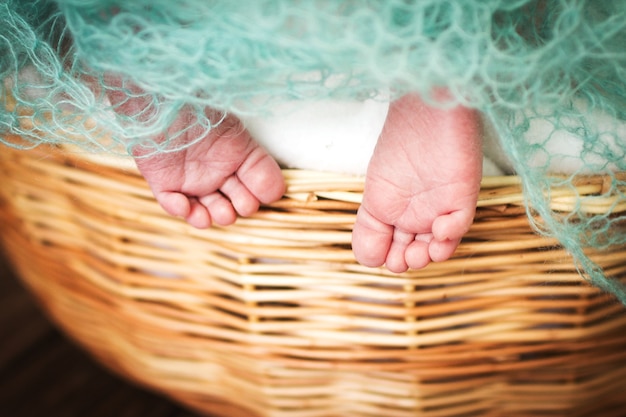 Pasgeboren baby voeten. kinderbenen in de rieten mand