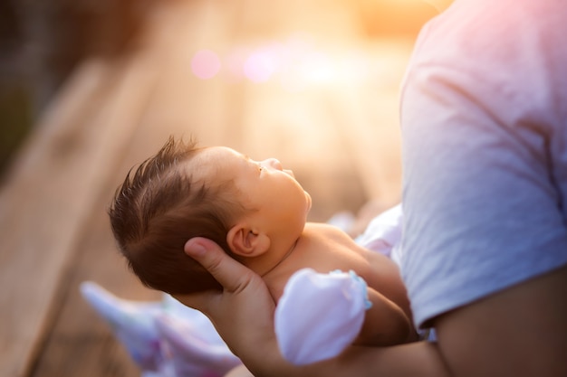 Pasgeboren babyjongen die in moederswapens rust.