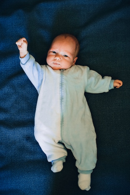 Pasgeboren babyjongen die op blauwe doek ligt