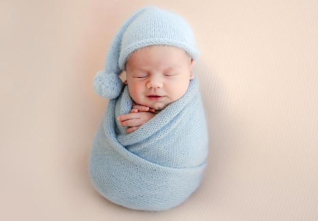 Pasgeboren babyjongen ingebakerd in blauwe stof slapen. baby kind kind rust tijdens studio fotoshoot