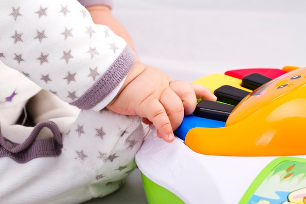 Pasgeboren babyjongen speelt met een speelgoedpiano