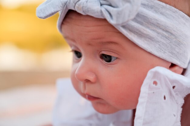 Pasgeboren babymeisje ligt op het strand in een witte jurk