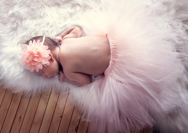 Foto pasgeboren babymeisje met een bloem in haar haar