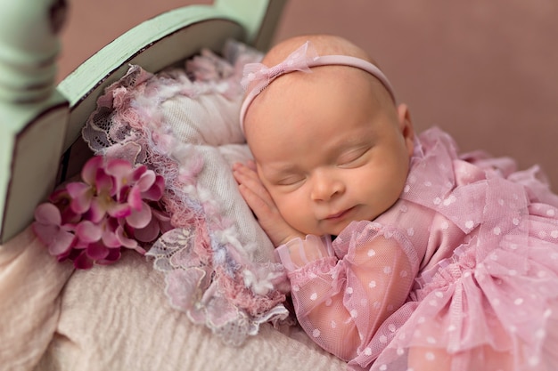 Pasgeboren babymeisje slapen in bed met roze tuin bloemen