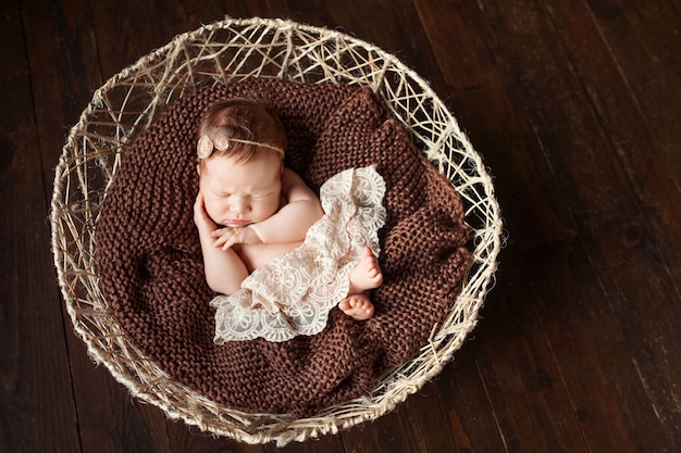 Pasgeboren babymeisje slapen in een mand