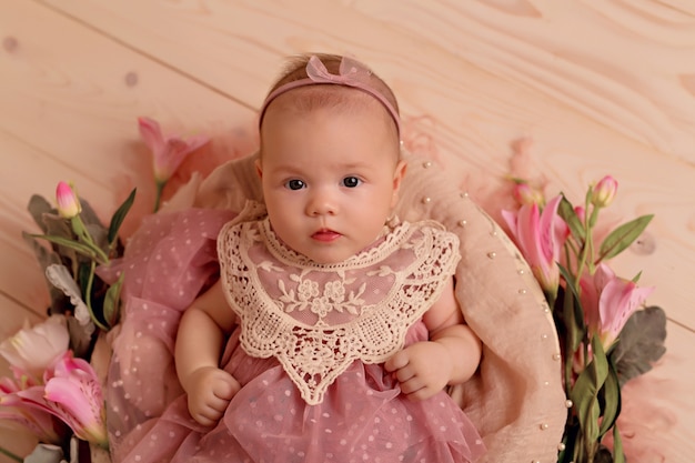 Foto pasgeboren babymeisje slapen in retro mand met roze tuin bloemen