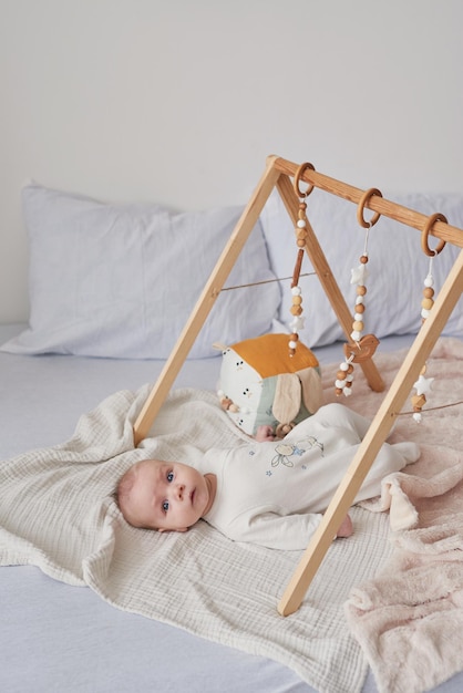 Foto pasgeboren peuterjongen liegt en speelt met educatief speelgoed. gelukkig moederschap en vaderschap. kraamkliniek en kliniek. vader en moeder dag. ontwikkeling in de vroege kinderjaren.