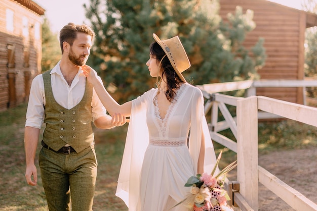 Pasgetrouwden in boho-stijl wandelen in de natuur, zomerdag