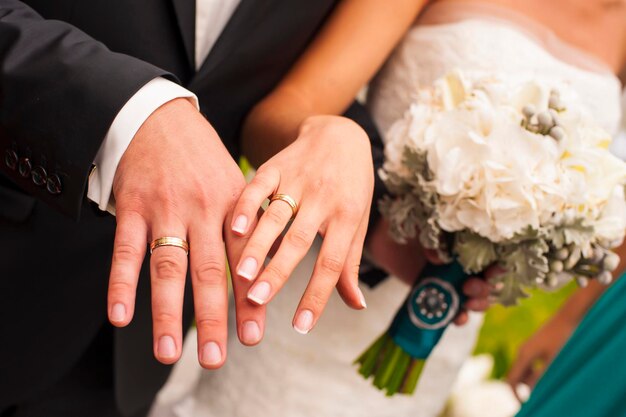Pasgetrouwden tonen hun handen met trouwringen.
