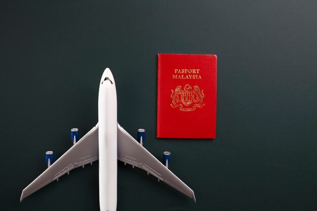 Foto paspoort en modelvliegtuig op zwarte achtergrond