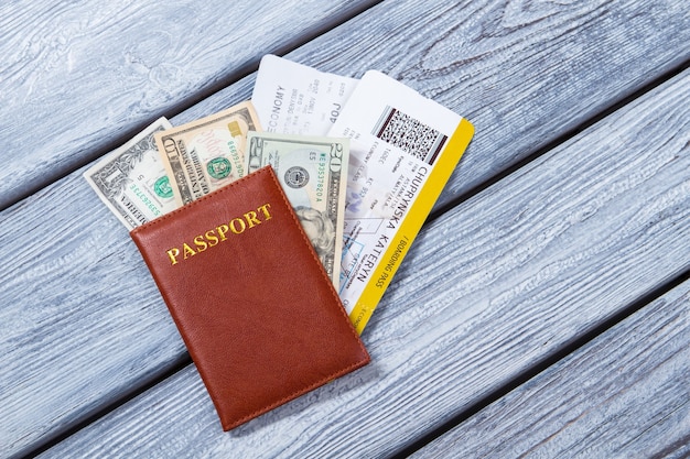 Paspoort met ticket en dollars. bruin paspoort en geld. document voor zakenreis. ticket voor de dichtstbijzijnde vlucht.
