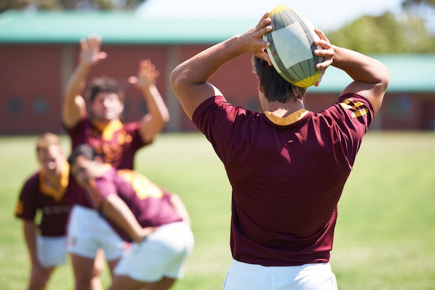 Pass de bal Achteraanzicht van een jonge rugbyspeler die een line-out neemt