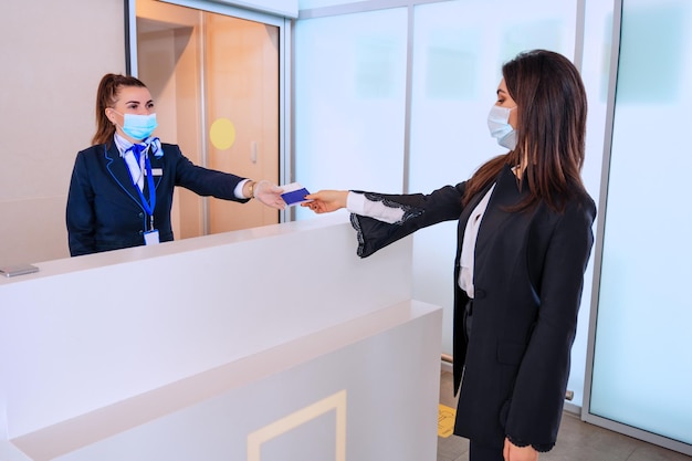 Passagier die zijn documenten voor check-in aan de luchthavenbeheerder geeft door balie