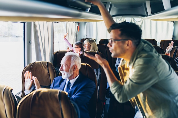 Passagiers zwaaien naar hun families vanuit de bus.