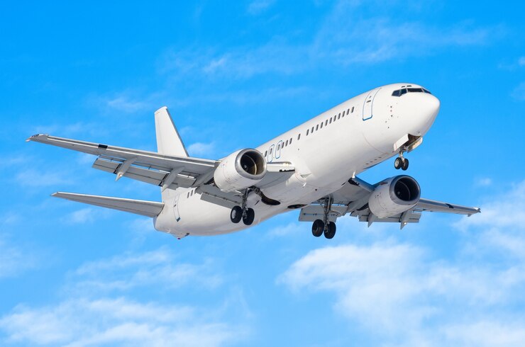 Foto passagiersvliegtuig met het chassis vrijgegeven voor de landing op de luchthaven tegen de blauwe lucht.