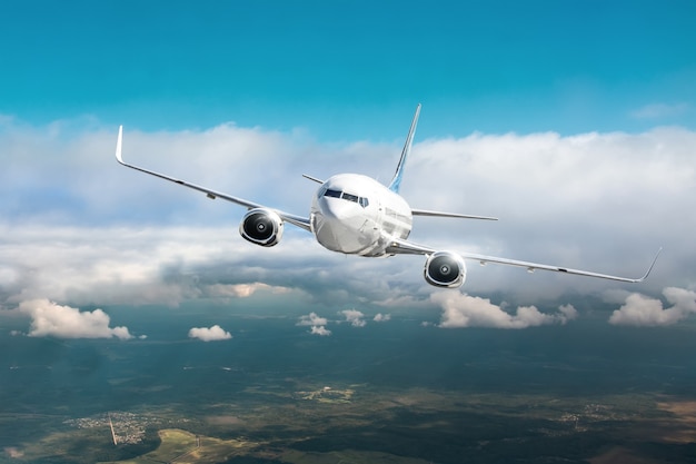 Passenger airplane fly in overcast clouds and blue sky.