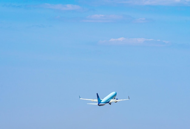 澄んだ青い空を背景に飛んでいる旅客機