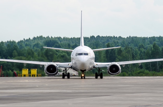 Пассажирский самолет на стоянке в аэропорту с носом вперед.