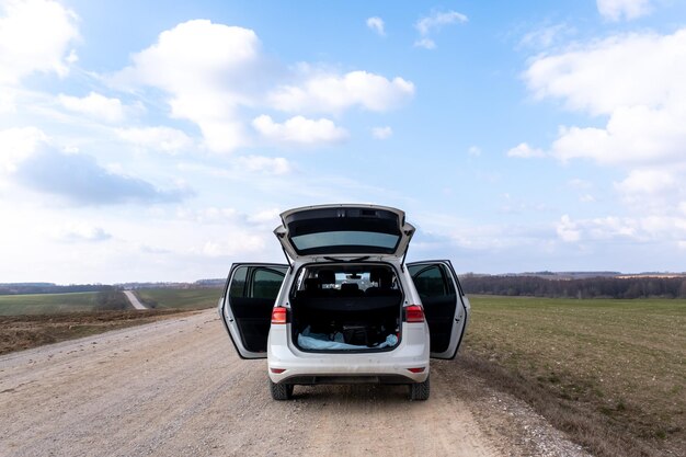 Photo passenger car on the road with open doors and trunk