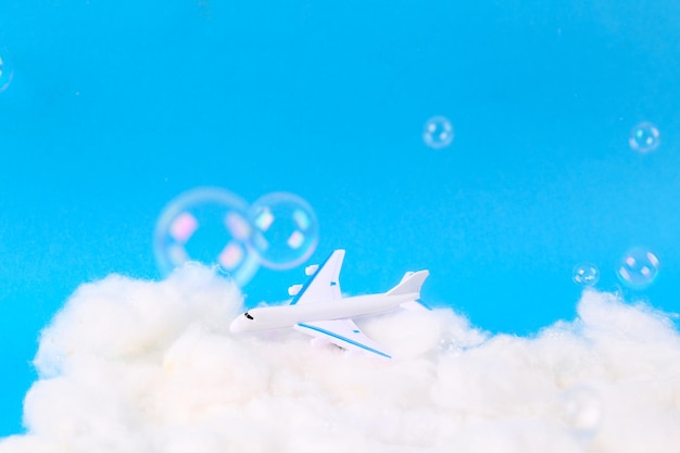 Photo passenger plane flying in the clouds with soap bubbles studio shot