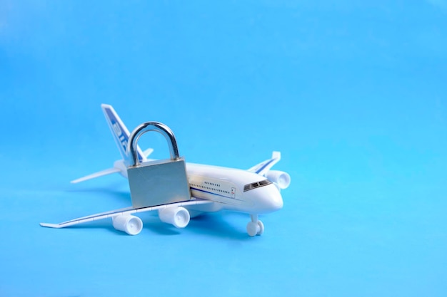 Passenger plane and lock on blue backgroundConcept of ban passenger flights