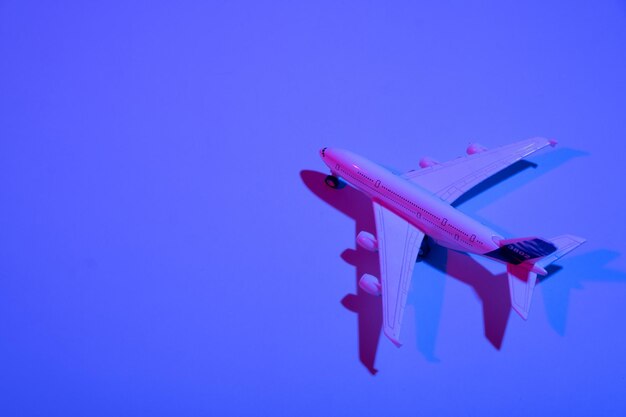 Photo passenger plane toy neon light minimalistic concept of air travel business travel