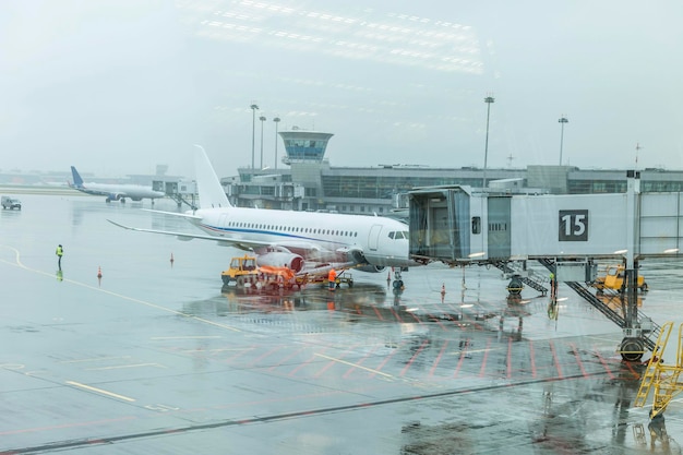 비오는 날 공항 건물 근처 비행장에 있는 여객기 관광 및 여행