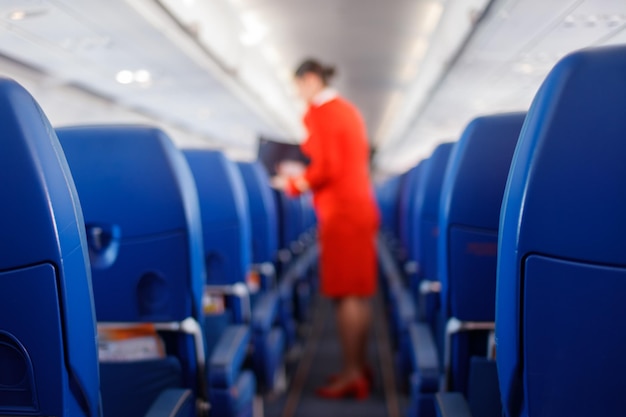 Foto sedile del passeggero in aereo interno dell'aereo e sfondo dell'hostess l'hostess fornisce servizi per i passeggeri concetto di viaggio di concetto di servizio