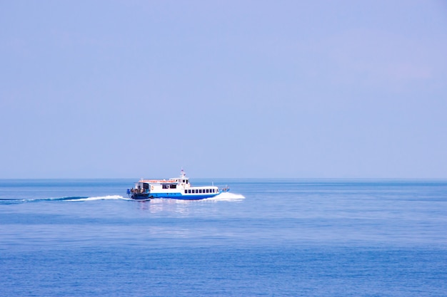 写真 青い空の日にタイの湾の海に浮かぶ観光客のための客船