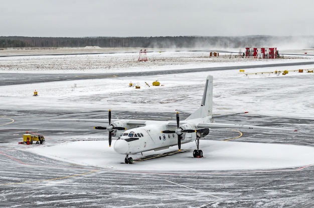 Photo passenger small airplane at the airport in winter in bad snow and blizzard weather.