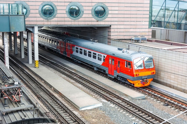 A passenger train is standing at the station platform waiting for departure