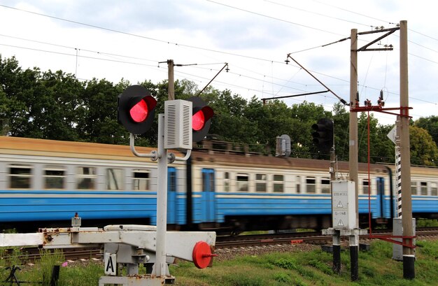 Passenger Train Rushes Past A Closed Crossing With Red Semaphore Light