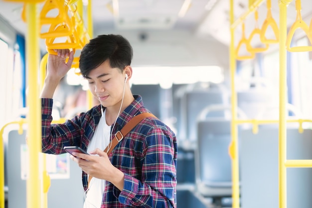 The passenger using mobile phone on the public bus.