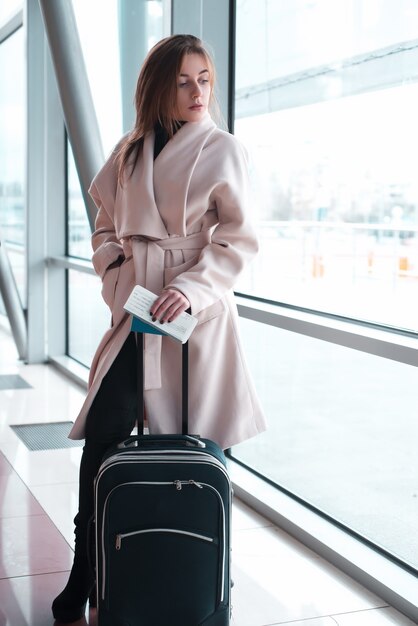 Passenger woman in airport waiting for air travel.