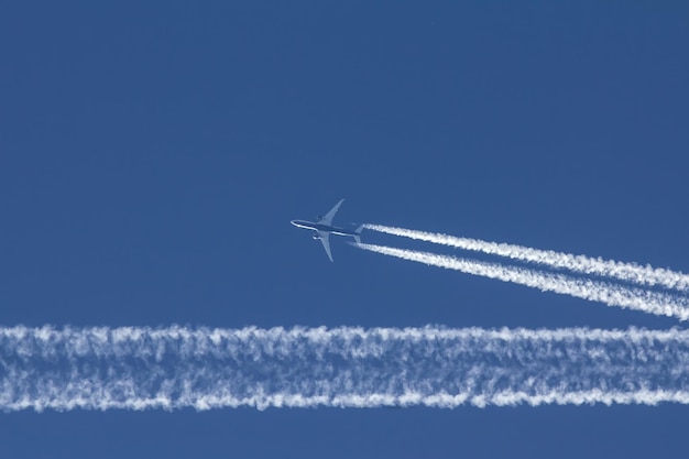 ジェット機が完璧な青い空を飛んでいる、望遠