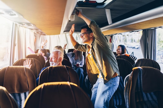 Passengers waving to their families from bus.